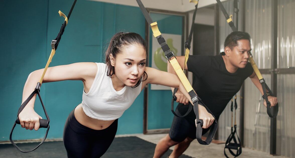 seorang pria dan wanita sedang melakukan olahraga bersama dalam sebuah ruangan